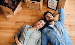 A couple lies on the floor of their new home