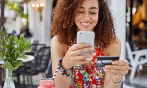 A woman uses her credit card to make a mobile purchase