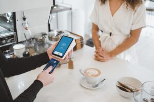 woman at cafe using instant approval credit card