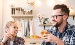 A father and his young daughter enjoy breakfast together