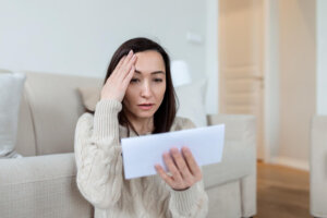 A woman is worried by a letter from her landlord.