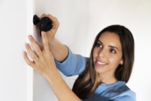 Woman adjusts home security camera