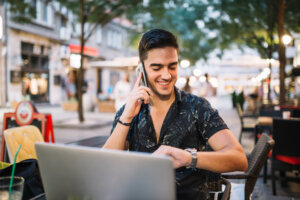 Young man works on his laptop at a European cafe