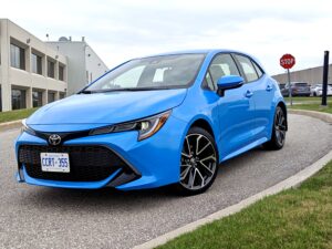 A blue Toyota Corolla sits on a long driveway