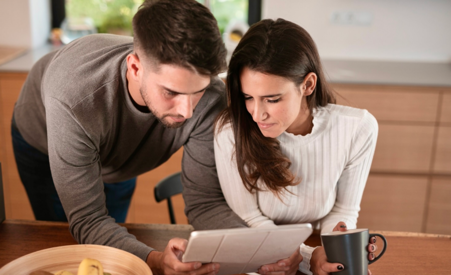 A young couple reads a home inspection report on a tablet