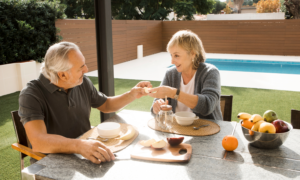 A couple enjoys breakfast beside a swimming pool