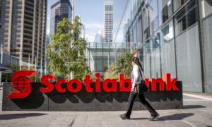 A woman walks past a Scotiabank sign